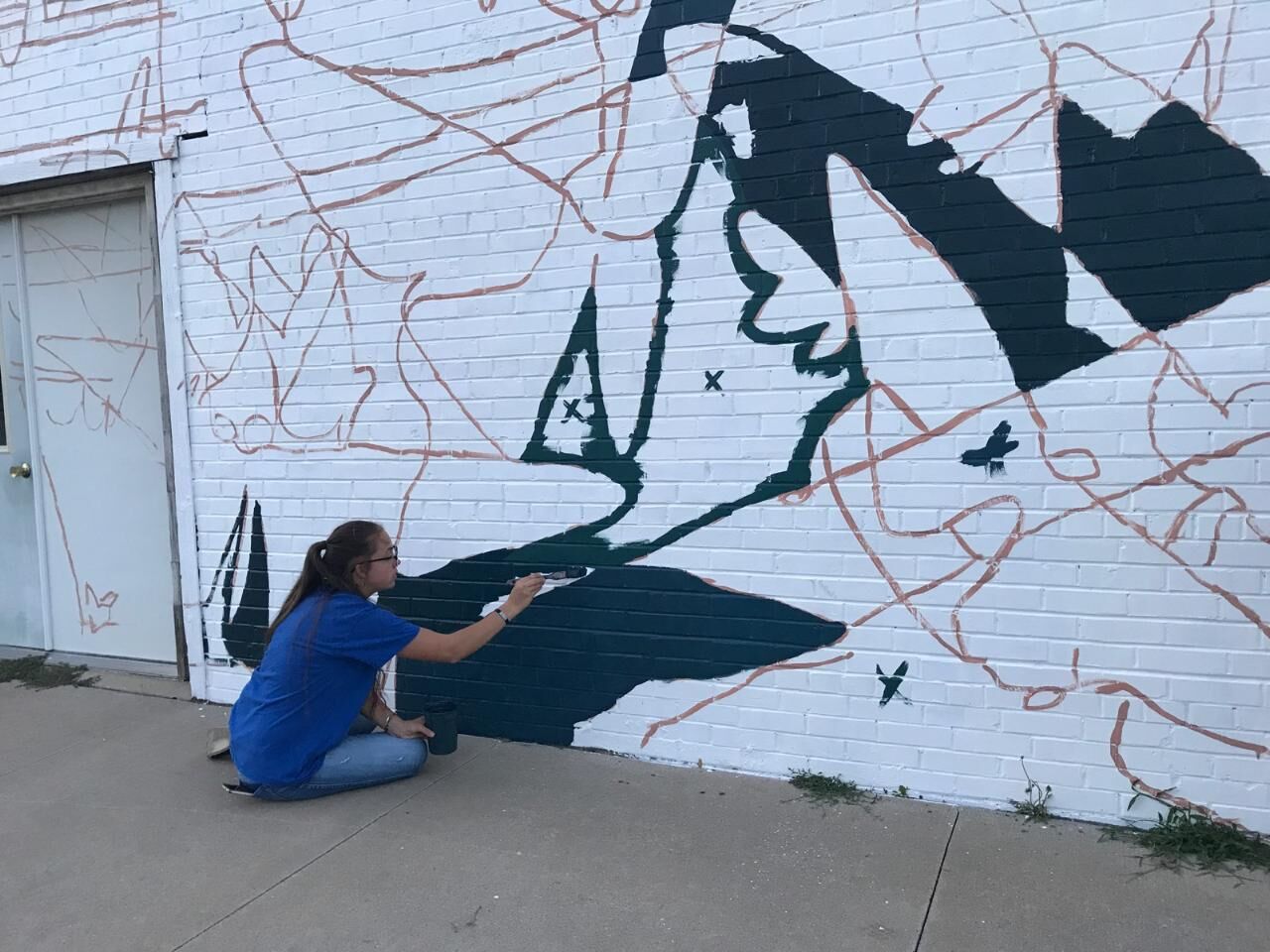 Lydia Hansen helps paint mural in Alton